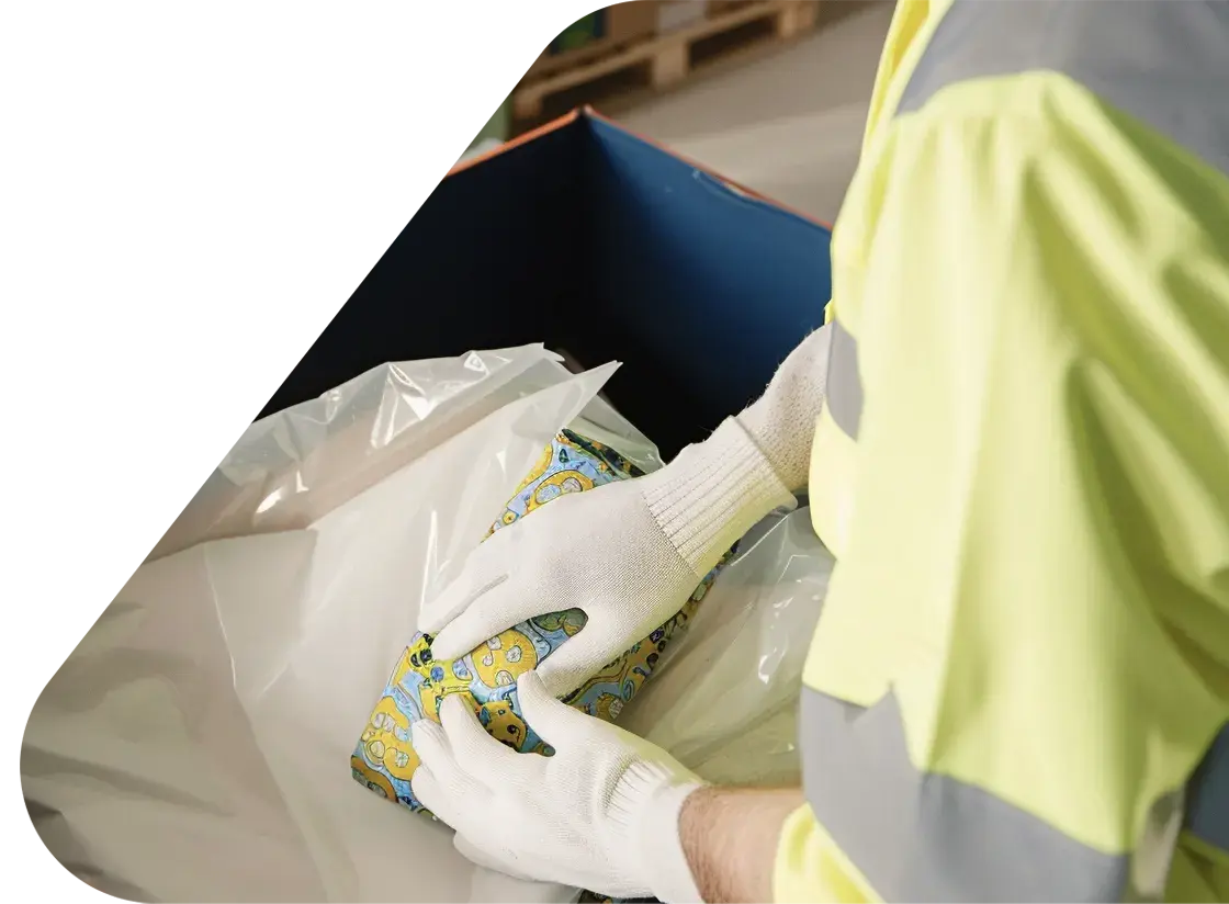 Person in high viz tabard and white gloves opening a returned box of items