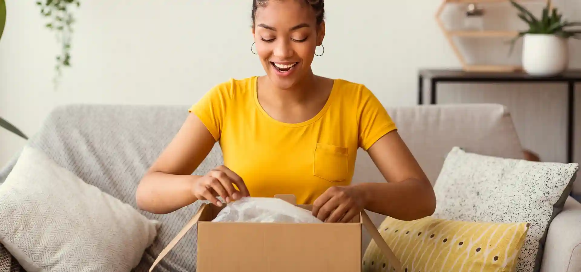 Woman opening a parcel and looking happy