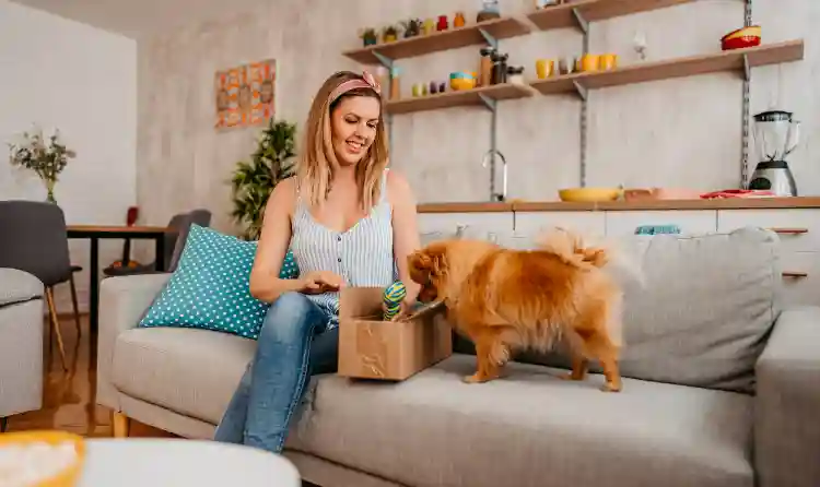 Woman Opening a pet supplies box with her pet dog